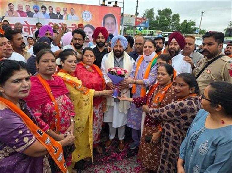 A large group of party workers, many of them women, gathered at a roadside welcome programme in Punjab