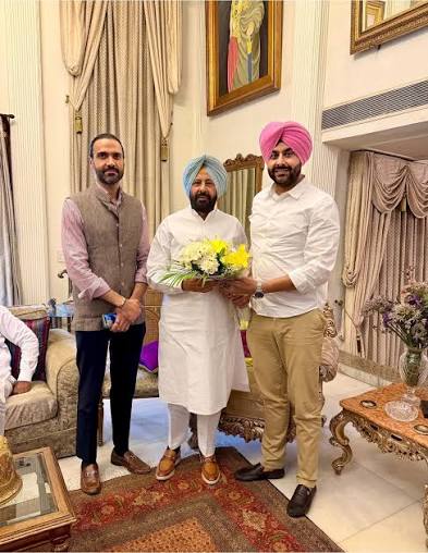 Kewal Singh Dhillon with two colleagues receiving a bouquet in a formal drawing room
