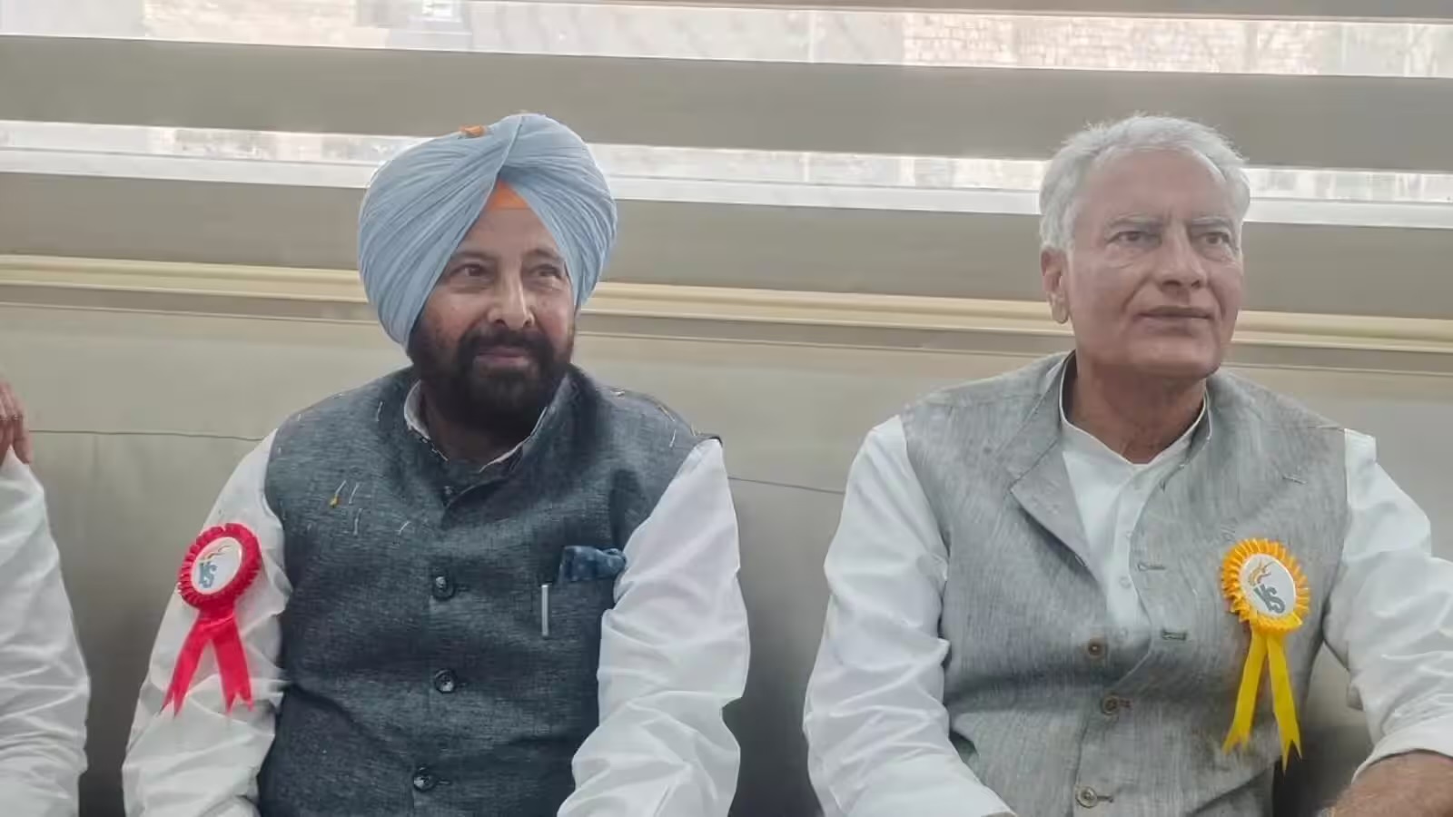 Kewal Singh Dhillon seated beside Sunil Jakhar at a party function, both wearing commemorative rosettes