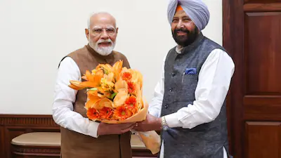 Kewal Singh Dhillon meeting Prime Minister Narendra Modi, exchanging a bouquet of flowers