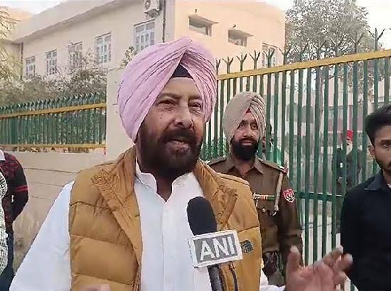 Kewal Singh Dhillon speaking to a television news reporter outdoors