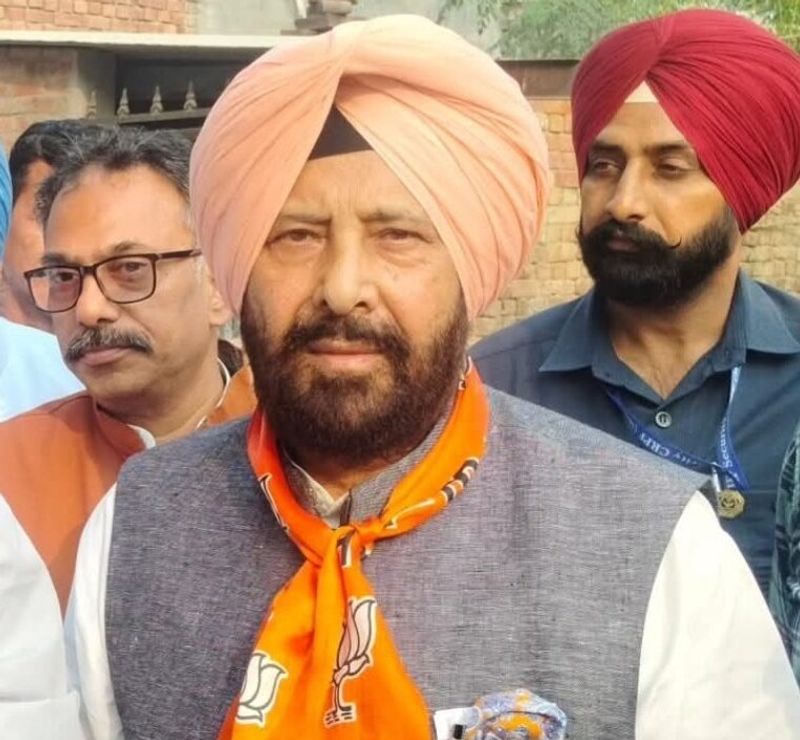 Kewal Singh Dhillon speaking to the media outdoors, flanked by colleagues and security personnel