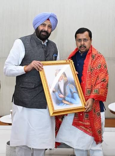 Kewal Singh Dhillon presenting a framed portrait to a visiting colleague at a formal meeting