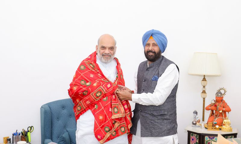 Kewal Singh Dhillon presenting a phulkari shawl to Union Home Minister Amit Shah at an indoor meeting
