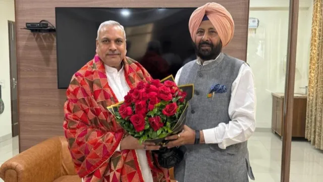Kewal Singh Dhillon presenting a bouquet to a senior colleague at an indoor reception